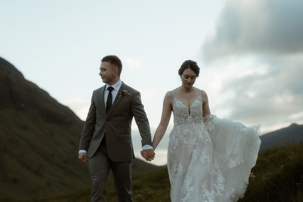 A bride and groom wander through the Scottish landscape after their elopement in Glencoe