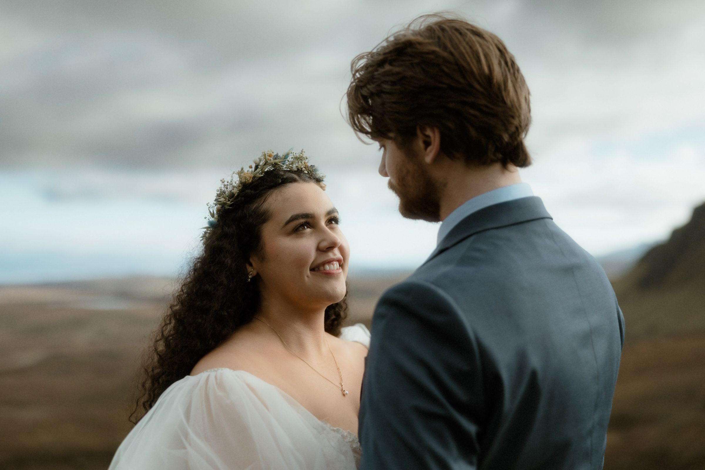 A couple stand together in the mountains of the Isle of Skye during their Scottish elopement